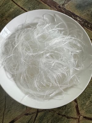 Cortar los fideos remojados en trozos más cortos y colocarlos en un plato.