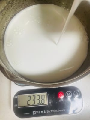 Letakkan panci kecil di atas kompor, tambahkan 30g gula pasir, lalu tuangkan 200ml susu dan 100ml santan. Untuk rasa yang lebih kaya, kurangi susu menjadi 150ml dan tambahkan 50g krim kental. Masak dengan api kecil hingga mulai mendidih; jangan sampai mendidih, karena teksturnya tidak akan lembut dan empuk.