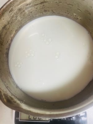 Letakkan panci kecil di atas kompor, tambahkan 30g gula pasir, lalu tuangkan 200ml susu dan 100ml santan. Untuk rasa yang lebih kaya, kurangi susu menjadi 150ml dan tambahkan 50g krim kental. Masak dengan api kecil hingga mulai mendidih; jangan sampai mendidih, karena teksturnya tidak akan lembut dan empuk.