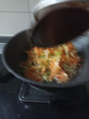 Pfanne erhitzen, 2 EL Öl hineingeben, gehackte Gewürze dazugeben, anbraten bis es duftet und die geriebenen Karotten und Zucchini dazugeben.