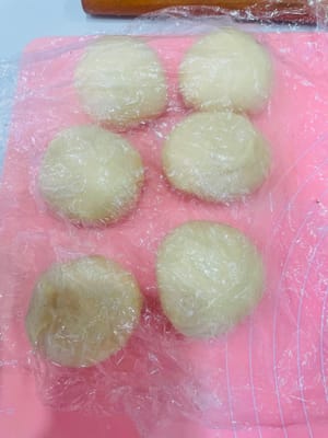 นำแป้งที่ขึ้นฟูแล้วมาวางบนพื้นผิวสำหรับนวดแป้ง และแบ่งออกเป็น 6 ส่วนเท่าๆ กัน

ปั้นแต่ละส่วนให้เป็นก้อนกลมเล็กๆ (ถ้าไม่รู้วิธี สามารถดูวิดีโอสอนสั้นๆ 10 วินาทีได้) คลุมด้วยพลาสติกแรป แล้วพักไว้ 15 นาที เพื่อให้แป้งคลายตัว