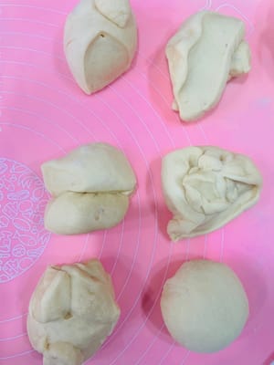 นำแป้งที่ขึ้นฟูแล้วมาวางบนพื้นผิวสำหรับนวดแป้ง และแบ่งออกเป็น 6 ส่วนเท่าๆ กัน

ปั้นแต่ละส่วนให้เป็นก้อนกลมเล็กๆ (ถ้าไม่รู้วิธี สามารถดูวิดีโอสอนสั้นๆ 10 วินาทีได้) คลุมด้วยพลาสติกแรป แล้วพักไว้ 15 นาที เพื่อให้แป้งคลายตัว