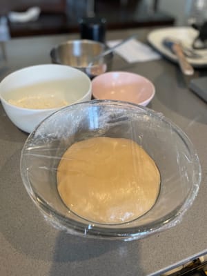 Rocíe un poco de aceite en sus manos, saque la masa, forme una bola, luego colóquela en un recipiente grande, cúbrala con film transparente y realice la primera fermentación. Si la temperatura ambiente es baja, puedes ponerlo en un horno a unos 30 grados para que fermente. El tiempo de la primera fermentación es de aproximadamente una hora.
