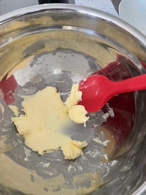 Busca un recipiente grande, coloca la mantequilla que haya estado a temperatura ambiente durante un tiempo y utiliza una espátula para presionarla y frotarla.