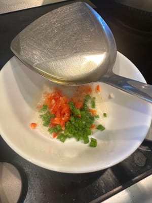 마지막으로, 다진 빨간 피망과 파에 뜨거운 기름을 부어 향이 날 때까지 볶습니다. 그 후 간장을 넣고 섞어줍니다.