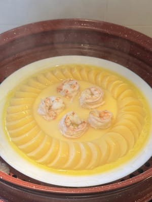 랩을 제거하고 새우를 굳은 달걀 위에 올려놓으세요. 3분 더 쪄주세요.