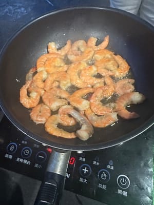 새우튀김: 팬에 기름을 두르고 달군 후, 양념에 재운 새우를 넣고 껍질이 노릇노릇하고 바삭해질 때까지 양면을 튀깁니다.