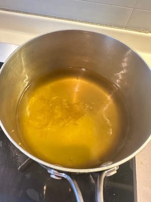 Luego, agregue el azúcar glas, baje el fuego a medio y deje que se derrita lentamente. RECUERDE NO MEZCLAR NI REVOLVER la olla mientras se derrite el azúcar glas. Deje que se derrita gradualmente.