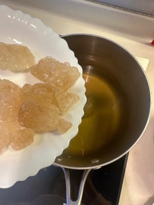 Luego, agregue el azúcar glas, baje el fuego a medio y deje que se derrita lentamente. RECUERDE NO MEZCLAR NI REVOLVER la olla mientras se derrite el azúcar glas. Deje que se derrita gradualmente.