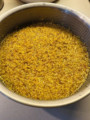 Mientras la masa del pastel de arroz fermenta, puedes preparar la miel de osmanto. Lava el osmanto con cuidado para no deformarlo.