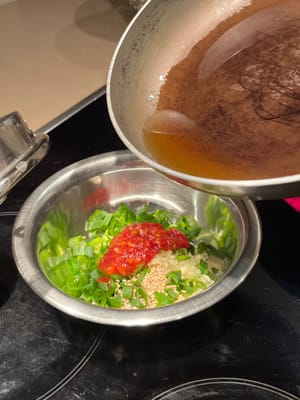 Ajoutez l'huile chaude au mélange de sauce chili à l'ail