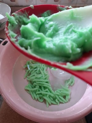 Prepare a bowl filled with water and ice cubes. Press the dough into a perforated container right in the bowl of ice water (press the dough while it is still hot). Do this until the dough is finished. Once it is done, set it aside.