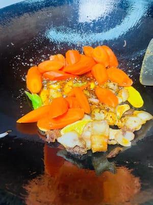 把扒手拉到鍋邊,放入蒜粒、薑片、蒜苗根莖,中小火炒出香味,再挖點紅油豆瓣或乾鍋醬,繼續小火炒出紅油,香得鄰居都嚟敲門。
再把紅蘿蔔片倒進去,和肉、醬料一起翻炒均勻,讓每片紅蘿蔔都裹上醬汁,看著就流口水。