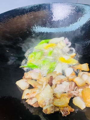 把扒手拉到鍋邊,放入蒜粒、薑片、蒜苗根莖,中小火炒出香味,再挖點紅油豆瓣或乾鍋醬,繼續小火炒出紅油,香得鄰居都嚟敲門。
再把紅蘿蔔片倒進去,和肉、醬料一起翻炒均勻,讓每片紅蘿蔔都裹上醬汁,看著就流口水。