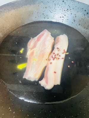 五花肉冷水下鍋,丟點料酒、薑、花椒或青蔥,開火燙水。水開後煮25分鐘,直接把紅蘿蔔也扔進去一起隔水蒸,蒸到用筷子能輕鬆戳透就成,省煤氣又省事兒,主打一個懶人大法。