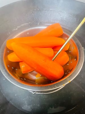 五花肉冷水下鍋,丟點料酒、薑、花椒或青蔥,開火燙水。水開後煮25分鐘,直接把紅蘿蔔也扔進去一起隔水蒸,蒸到用筷子能輕鬆戳透就成,省煤氣又省事兒,主打一個懶人大法。