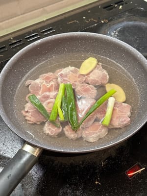 Masukkan buntut sapi, daun bawang, jahe, dan arak masak ke dalam air dingin untuk merebus. Setelah mendidih, biarkan mendidih selama 5 menit lagi