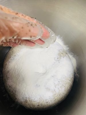Dopo che l'impasto è lievitato, premetelo delicatamente con un dito inumidito con acqua. Se non torna indietro, è lievitato abbastanza. Quindi, aggiungete la farina e continuate a impastare fino a quando non ci saranno più buchi visibili all'interno dell'impasto quando lo tagliate. Questo è fondamentale per garantire che i panini al vapore o i baozi abbiano una superficie liscia e piana.