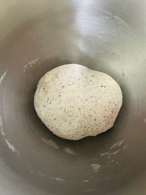 Mettere gli ingredienti per l'impasto (farina, sesamo nero in polvere, lievito, acqua, sale, zucchero e latte in polvere) in una ciotola e impastare fino a ottenere un impasto liscio. Coprire con pellicola trasparente e lasciare lievitare in un ambiente adatto fino al raddoppio del volume.