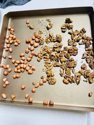Mentre l'impasto lievita, preparate il ripieno al sesamo nero. Tostate le arachidi e i gherigli di noce in forno spento a 180°C/380°F per 5 minuti. Dopo il raffreddamento, strofinate le arachidi e le noci con le mani per rimuoverne la buccia. Quindi, tritatele o frullatele in un robot da cucina (non è necessario ridurle in polvere; è meglio conservare i granelli).