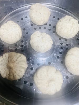 包子製作步驟:
1.取每個約50克的劑子,用手掌壓扁後,用擀麵杖擀成中間厚、邊緣薄的圓形面皮。
2.取一份搓圓的黑芝麻餡料放入面皮中央,將面皮邊緣向上收攏並注意收緊收口,避免蒸製時開裂。
3.將包好的包子生胚放入蒸籠,靜置醒發至體積變為原嚟的1.5倍即可。