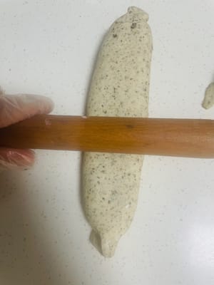 Rotolo di fiori di twill. Procedimento:
1. Stendere l'impasto in una sfoglia rettangolare larga circa 20 cm e lunga 25 cm.
2. Distribuire uniformemente il ripieno di sesamo nero sulla superficie della sfoglia e arrotolarla da un'estremità all'altra. Spruzzare un po' d'acqua sulla chiusura (è possibile arrotolare prima i bordi sottili per farli aderire meglio).
3. Stringere bene le estremità durante l'arrotolamento per evitare che il ripieno fuoriesca. Quindi, capovolgere l'impasto e premerlo delicatamente con un mattarello per renderlo uniformemente spesso.
4. Mettere l'impasto preparato in una vaporiera e tagliare nella lunghezza desiderata. Lasciarlo lievitare fino al raddoppio del volume.