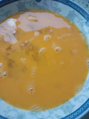 Pecahkan dua butir telur ke dalam piring, tambahkan satu sendok teh kaldu ayam dan sisihkan.