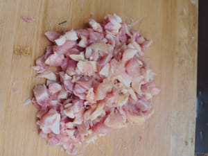 Zuerst die Hähnchenschenkel entbeinen und in kleine Würfel schneiden.