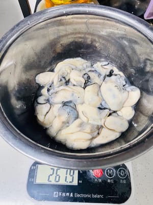 Ambil tiram, tambahkan tepung secukupnya, gosok perlahan (agar tiram tidak rusak), lalu bilas dengan air beberapa kali (atur aliran air agar tiram tidak pecah), ulangi proses ini hingga air jernih, angkat tiram, tiriskan, dan sisihkan.