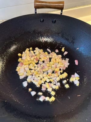 In einer erhitzten Pfanne mit Öl Knoblauch, Ingwer und Schalotten anbraten, bis sie duften.