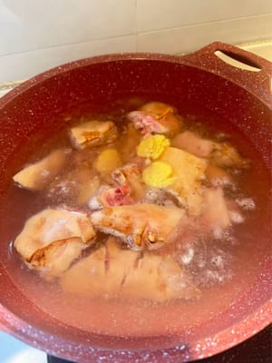 Die Schweinshaxen blanchieren, um sie zu reinigen. Dazu die benötigten Zutaten in kaltem Wasser blanchieren. Sobald das Wasser kocht, 3 Minuten blanchieren lassen.