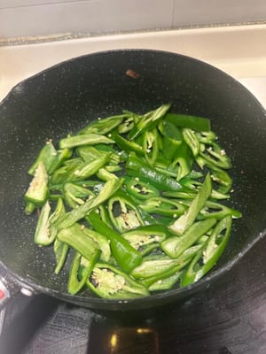 in una padella SENZA olio, aggiungere i peperoncini verdi e anche un po' di sale che aiuta i peperoncini ad ammorbidirsi