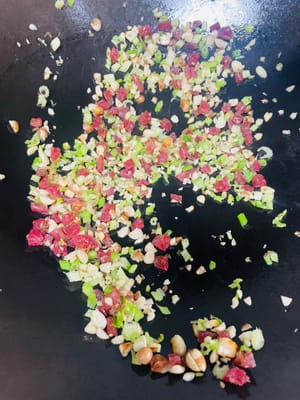 材料を炒める：中華鍋に少量の油をひき、さいの目に切った広東ソーセージを加えます。弱火で香りが立つまで炒めます。刻んだピーナッツとセロリを加え、香りが立つまで炒めます。火を止め、水気を切った千切り大根を中華鍋に加えます。