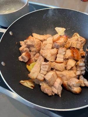 Once the scallions are slightly golden brown, add the pork belly and stir-fry quickly over high heat for one minute.