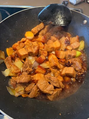 Add light soy sauce along the edge of the pan, then pour in the caramelized sugar water and stir-fry evenly.