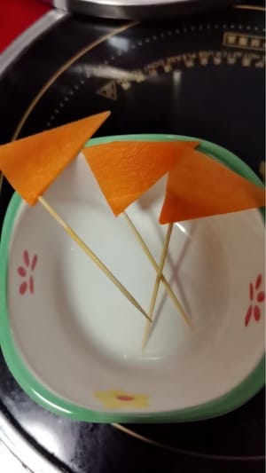 Cortar la zanahoria en rodajas finas triangulares. Pincharlas con un palillo y reservar.