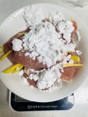 Marinar la carne: agregar jengibre rallado, 1/4 de cucharada (aproximadamente 1 gramo) de pimienta en polvo, 10 gramos de vino de cocina y 3 gramos de sal, mezclar bien, luego agregar 15 gramos de fécula de papa y dejar marinar durante 1 hora. Yo suelo marinarlo un día antes y meterlo en el frigorífico, así tengo más tiempo y puedo prepararlo con más tranquilidad.