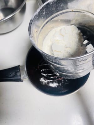 Sift in the cake flour: Sift 70g of cake flour into the chocolate mixture. Stir gently in an N-shaped pattern to ensure that the flour and liquid are fully combined to form a uniform egg yolk paste. Set aside.