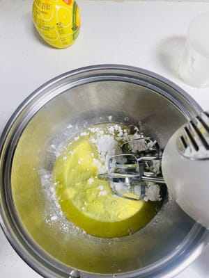 Beating the Egg Whites:
Use an electric whisk to beat the egg whites, adding 40g of sugar in three batches:
First: When the egg whites form large, fish-eye bubbles, add 1/3 of the sugar and beat on low speed.
Second: When the egg whites are fine and smooth, add 1/3 of the sugar and beat on medium speed.
Third: When streaks appear, add the remaining sugar. Beat on low speed until soft peaks form (the egg whites should form an inverted triangle when the whisk is lifted and should not fall over when a chopstick is inserted).