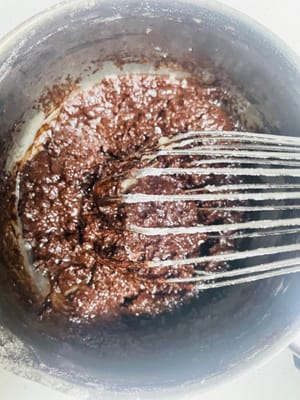 케이크 밀가루 체 치기: 케이크 밀가루 70g을 초콜릿 혼합물에 체 쳐 넣습니다. 밀가루와 액체가 완전히 섞여 균일한 달걀노른자 반죽이 되도록 N자 모양으로 살살 저어줍니다. 따로 둡니다.