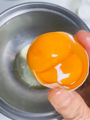 Separate the egg yolks and egg whites carefully. Add the egg yolks to the prepared chocolate egg yolk batter, stirring evenly in an N-shape (if you're lucky, you'll get a double yolk). Pour the egg whites into a large, salt-free, water-free bowl.