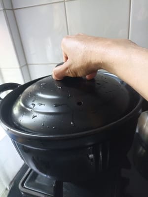 Decken Sie den Behälter ab und kochen Sie den Reis 15 Minuten lang, schalten Sie dann die Hitze aus und lassen Sie ihn 20 Minuten lang ruhen.