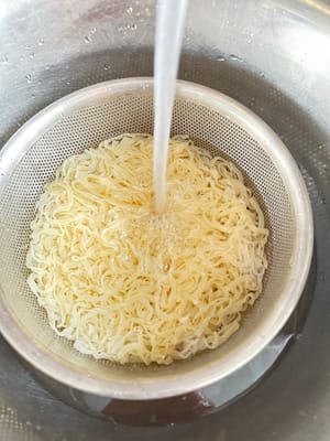 불을 끄고 면을 체에 밭쳐 물기를 뺍니다. 용기에 담아 흐르는 물에 두 번 헹군 후 물기를 빼고 나중에 사용합니다.