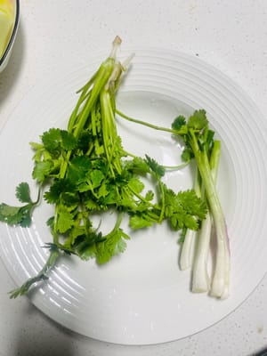 Preparazione del coriandolo: Lavare il coriandolo e le foglie bianche del cipollotto, asciugarli con carta da cucina e metterli da parte per un utilizzo successivo.