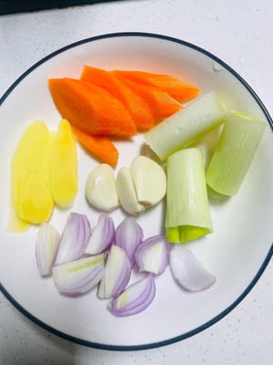 Preparare le verdure: tritare carote, cipollotti, cipolle, zenzero e aglio e mettere da parte. Asciugare con carta assorbente.