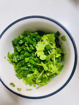 Tritare finemente il coriandolo e i cipollotti e metterli da parte.