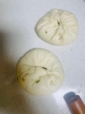 Vaporisez un peu d’huile sur le plan de travail et les gants, sortez la pâte fermentée et divisez-la en 5 boules. À l’aide d’un rouleau à pâtisserie, étalez-la finement, ajoutez la garniture et fermez le dessus comme un petit pain, dessus vers le bas. Ensuite, affinez légèrement la pâte et laissez-la reposer 20 à 30 minutes pour la laisser fermenter à nouveau.
