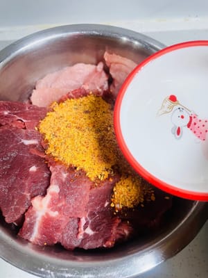 Marinar y mezclar. Verter la marinada sobre la carne, luego añadir la salsa de ostras y el vino blanco o de cocina. Mezclar a mano hasta que cada pieza de carne quede cubierta con la marinada. (Preparé 2 jin de cada uno de los sabores picante y de cinco especias; cada 2 jin de carne cruda rinde aproximadamente 475 gramos de producto terminado).