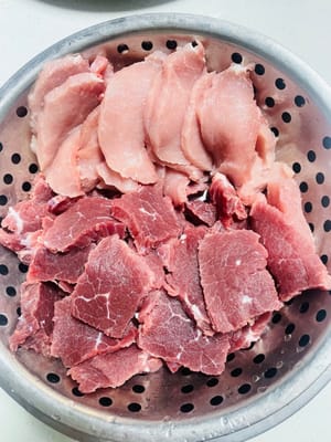 Corte y preparación de la carne. Primero, corte la carne en rodajas finas de unos 2 mm de grosor. Lávela y escurra bien el agua; de lo contrario, quedará pastosa después de asarla.