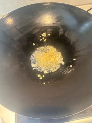 锅热倒油爆香蒜粒。姜粒
